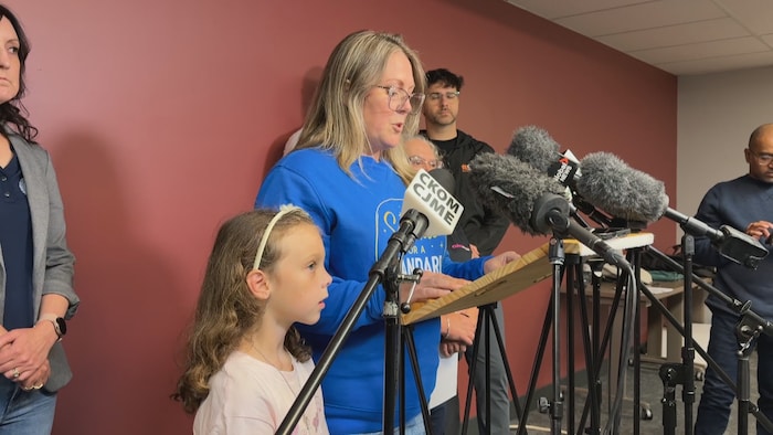 Kinsley, âgée de huit ans, atteinte de diabète de type 1 depuis quelques mois maintenant, au côté de sa maman Jennifer Simmons devant un pupitre qui s'adresse aux journalistes. 
