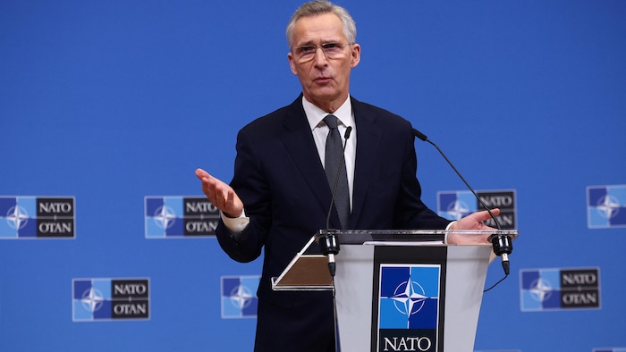 Jens Stoltenberg s'adresse à la presse derrière un lutrin identifié OTAN.