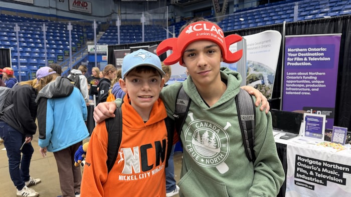 Deux jeunes devant des kiosques.