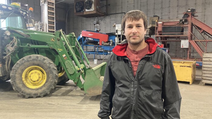 Jérémie Therrien devant un tracteur.