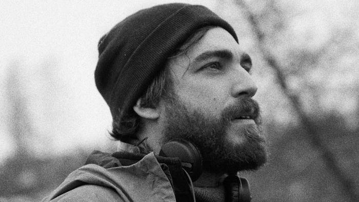 Photo en noir et blanc d'un homme portant une tuque. 