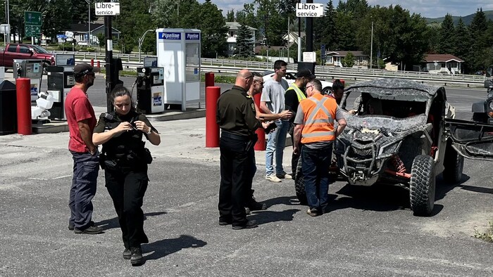 Des policiers et des gens autour d'un VTT.