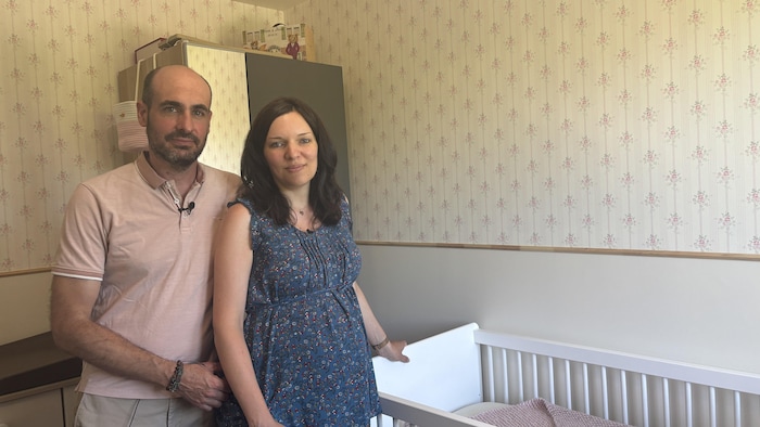 Deux personnes posent devant la caméra dans une chambre pour enfants.