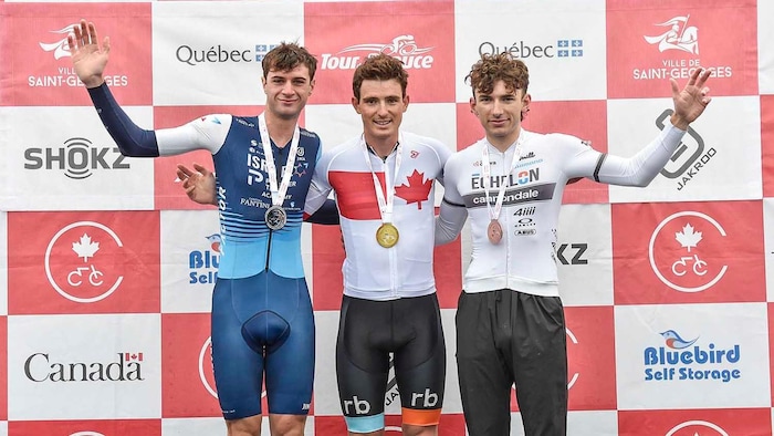 Trois cyclistes sur un podium.