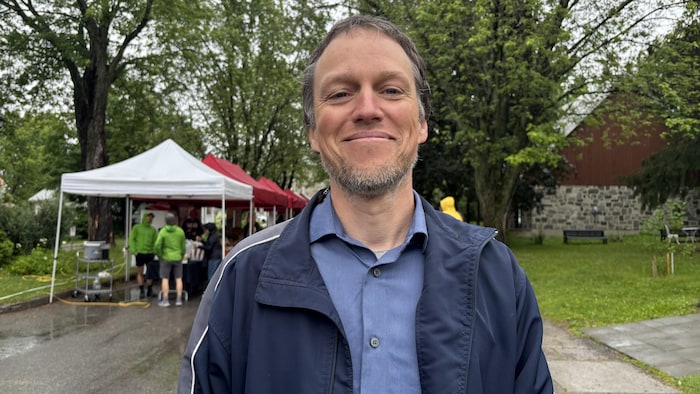 Il sourit devant le marché public.