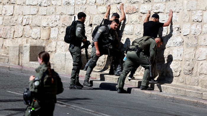 La police des frontières israélienne fouille des Palestiniens près de la porte des Lions dans la vieille ville de Jérusalem, quelques jours après l'attaque du Hamas en sol israélien.