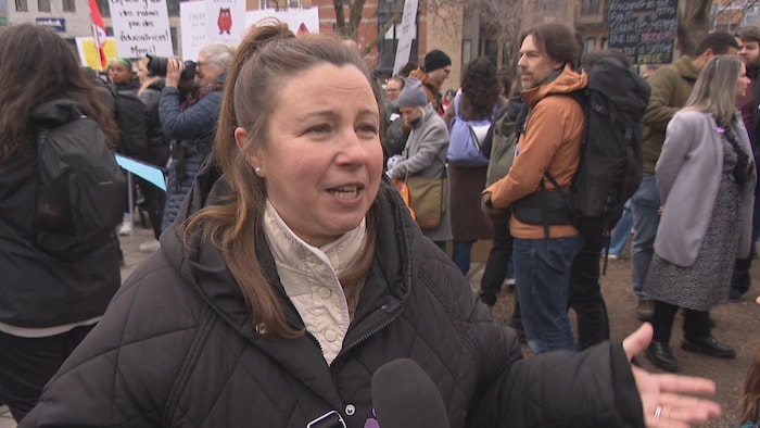 Une femme répond à des questions lors d'une manifestation.