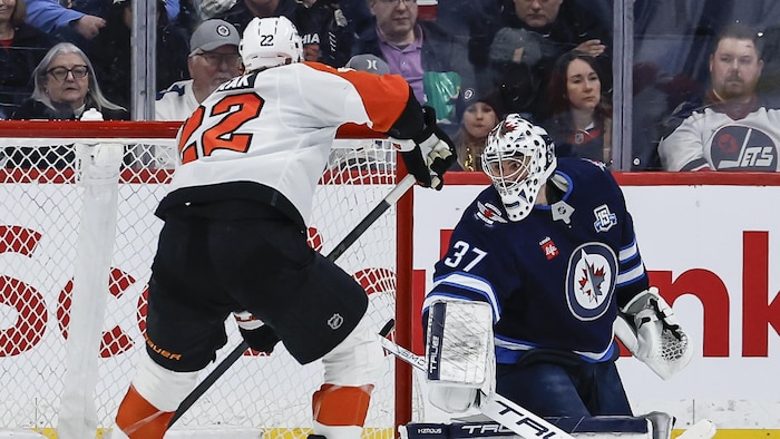 Le guardien de but des Jets, Connor Hellebuyck, manque d'arrêter le but de Christian Dvorak.