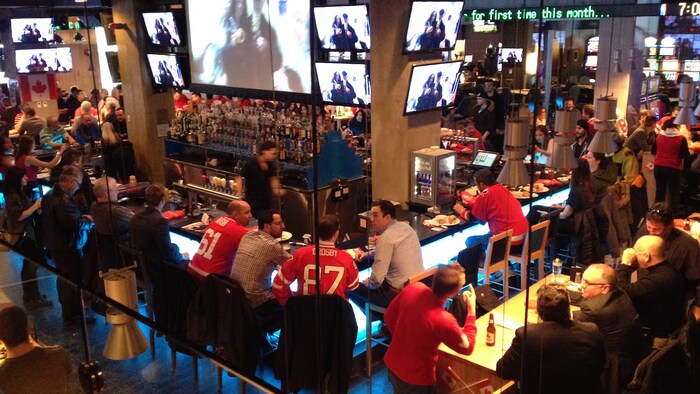 Des partisans de hockey sont assis dans un bar.