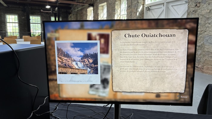 Un écran d'ordinateur affiche un panneau d'information sur la « Chute Ouiatchouan », comprenant du texte explicatif et l'image d'une chute d'eau.
