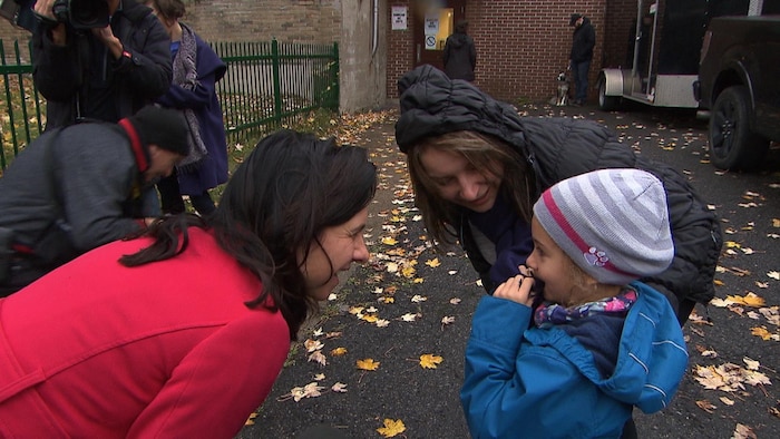 Valérie Plante (à gauche) s'entretient avec une mère (au centre) qui accompagne son enfant (à droite) au « petit bureau de vote » dans un arrondissement de Montréal le 5 novembre 2017.
