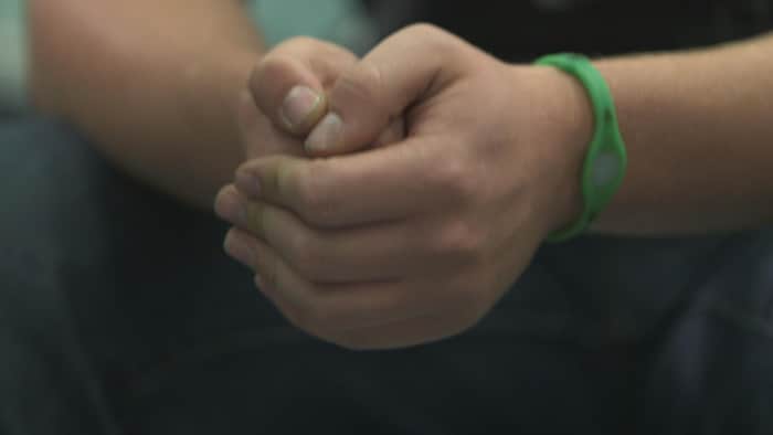 Gros plan sur les mains d'un jeune garçon de la D P J.