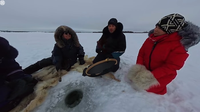 Des Inuit discutent sur la glace.
