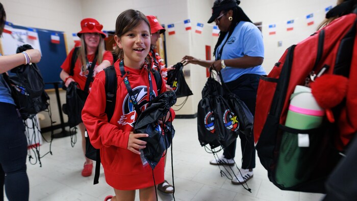 Une jeune fille souriante qui marche.