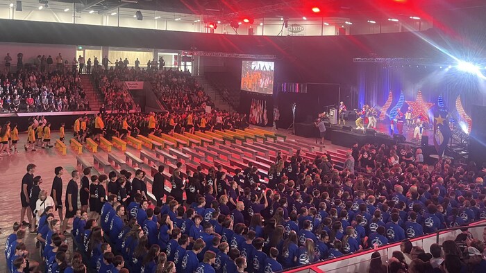 Une cérémonie qui met en scène des jeunes et des drapeaux.