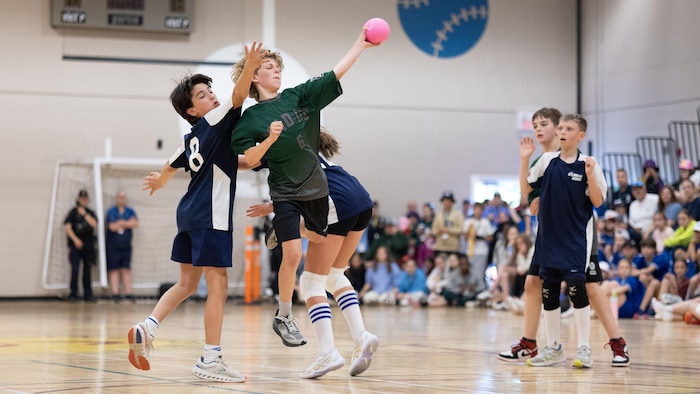 Des joueurs de mini-handball en action sur le terrain. 