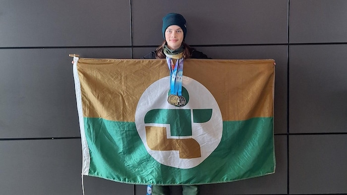 Raphaël Léger tient le drapeau de l'Estrie. 