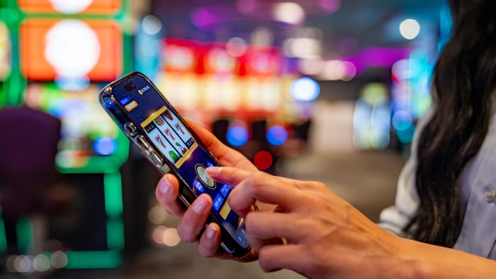 Une femme joue sur son téléphone portable dans un casino.