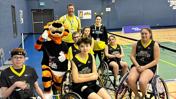 L'équipe de basketball en fauteuil roulant sourit à la caméra.