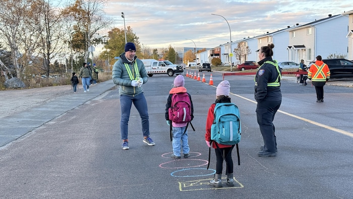 Des jeunes et des bénévoles occupent une rue bloquée pour l'arrivée des élèves.