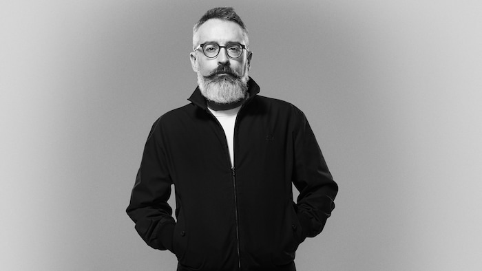 Portrait en noir et blanc d'un homme portant une moustache et une barbe.