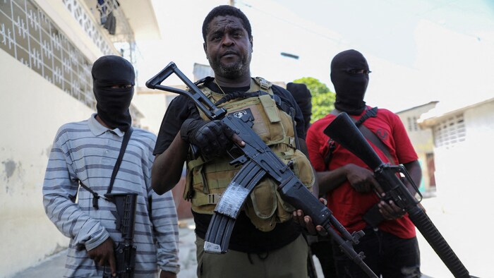 جيمي ’’باربيكيو‘‘ شيريزييه (وسط الصورة)، أحد قادة العصابات المسلحة في هايتي، وهو ضابط شرطة سابق، محاطاً ببعض رجاله عقب مؤتمر صحفي عقده في العاصمة بور أو برينس في 5 آذار (مارس) 2024.