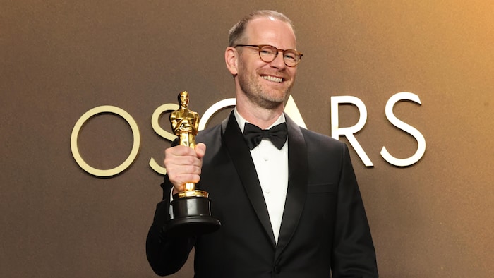 L'homme pose avec son Oscar.
