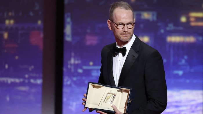 Le cinéaste tient son prix sur scène.