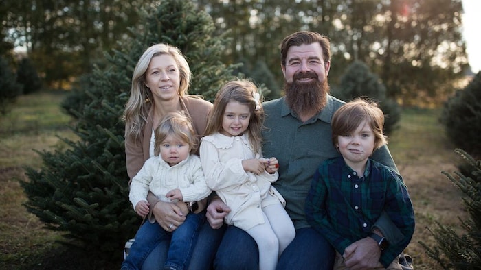 Joanna McCabe pose avec son conjoint et ses trois jeunes enfants à l'extérieur.