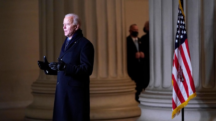 Joe Biden devant les caméras et devant le drapeau américain. 