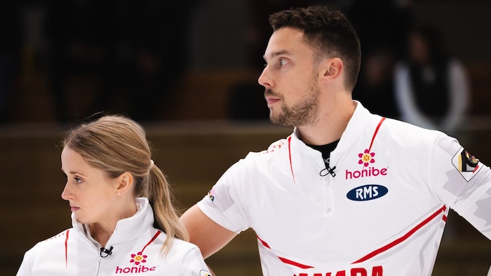 Jocelyn Peterman et Brett Gallant regardent vers leur droite sur la glace.