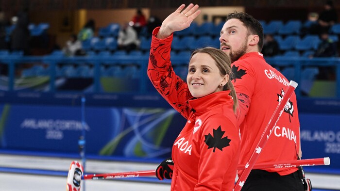 Jocelyn Peterman et Brett Gallant, sur la glace, se retournent en saluant la foule.