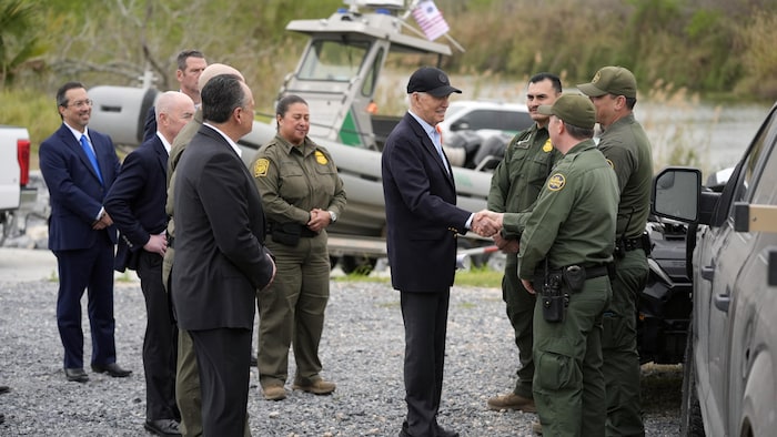 Joe Biden entouré de membres de la garde nationale. Il serre la main à un homme. 