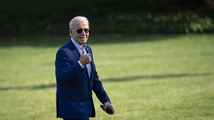 Joe Biden salue les journalistes sur la pelouse de la Maison-Blanche.