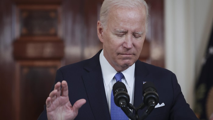 Le président Joe Biden, visage bas, les yeux fermés, en conférence de presse. 