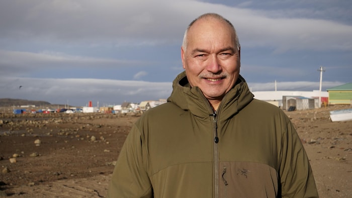 Joe Savikataaq devant une vue d'Iqaluit.