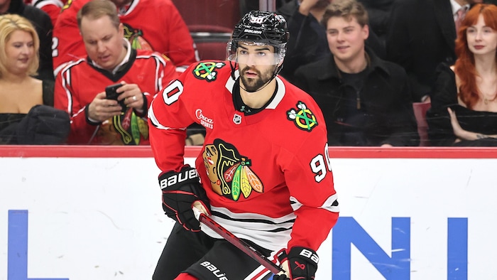 Dans l'uniforme des Blackhawks de Chicago, Joe Veleno patine pendant un match. 