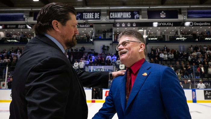 Joël Perrault et Gardiner MacDougall se serrent la main au centre de la patinoire. 