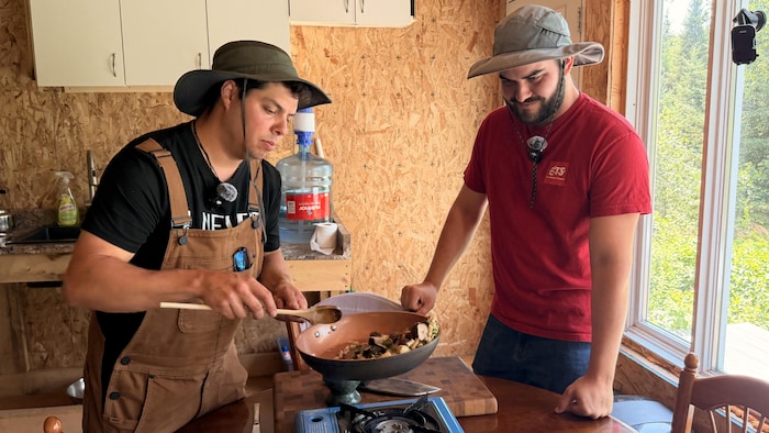 Deux hommes cuisinent.