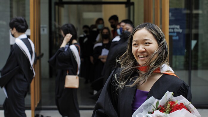Joey Chan sort de l'université avec un grand sourire après avoir reçu son diplôme. 