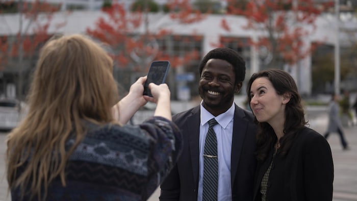 John Atoyebi et Emily Lowan posent pour une photo prise sur un téléphone.