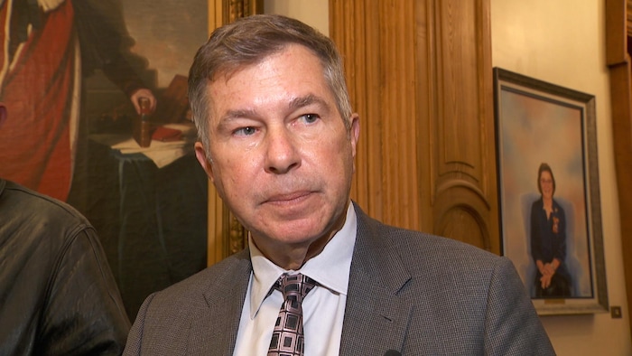 Le ministre parle à un groupe de journalistes.