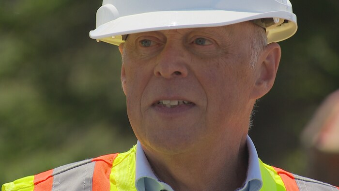 Le ministre porte un casque de chantier.