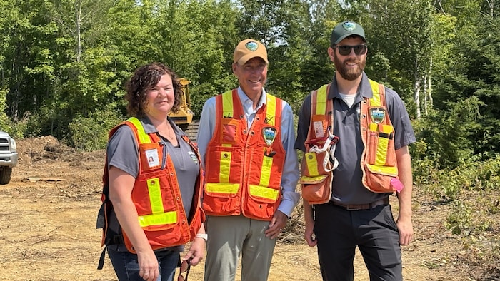 John Herron et deux personnes en habits de chantier.