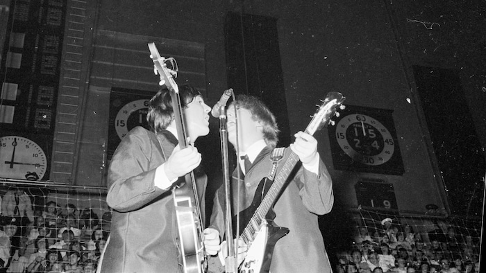 Paul McCartney et John Lennon chantent en harmonie lors du premier concert des Beatles à Toronto, en septembre 1964.