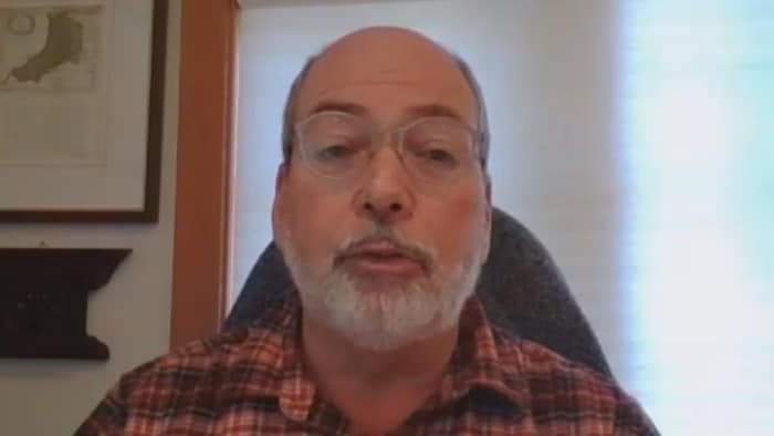 John Pomeroy regardant la caméra de son ordinateur pendant une réunion virtuelle.