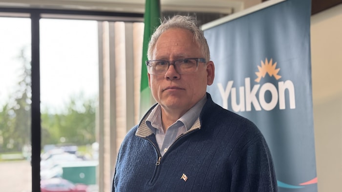 John Streicker, L'Air serious, in front of a banner with the word Yukon.