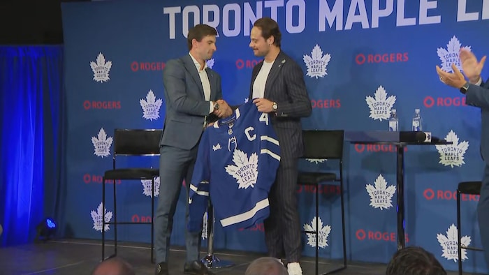 John Tavares et Auston Matthews se serrent la main lors d'une conférence de presse.