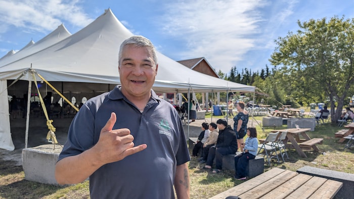 Johnny Régis devant une tente événementielle.