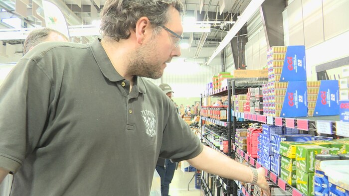 Jon Iskiw, propriétaire du magasin Tundra Supply, montre le prix des munitions le 1er mars 2025.
